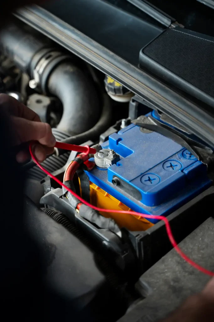 A trained technician performing a free battery health check and testing the vehicle’s charging system under the bonnet.