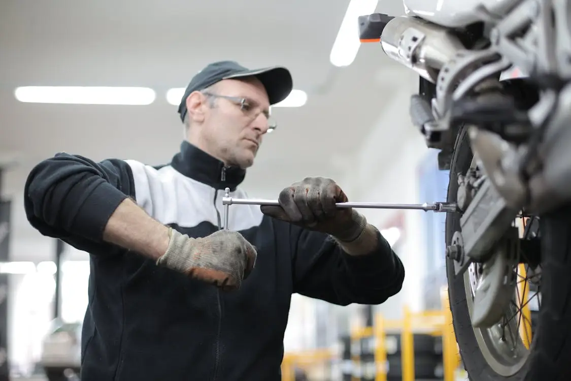 Mechanic repairing vehicle wheel area